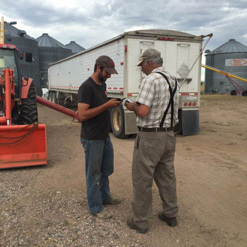 two farmers by a truck